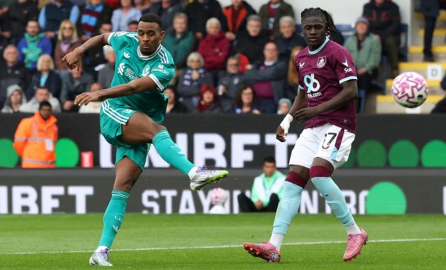 Burnley's Loum Tchaouna looks on as Liverpool's Ryan Gravenberch shoots at goal