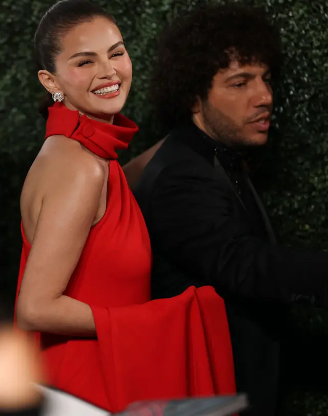 Selena Gomez in a red dress and Benny Blanco in a black suit
