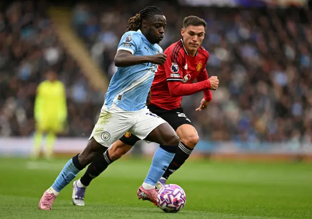 Jeremy Doku (L) runs with the ball shadowed by Manchester United's Uruguayan midfielder Manuel Ugarte