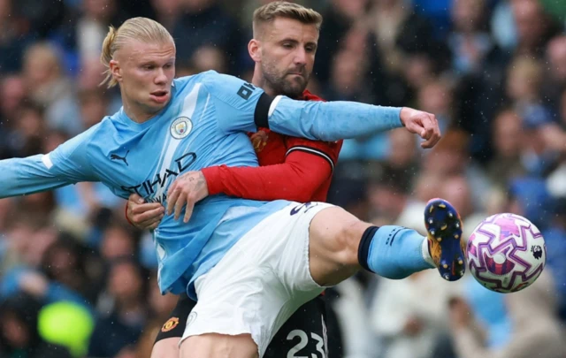 Manchester City's Erling Haaland in action with Manchester United's Luke Shaw