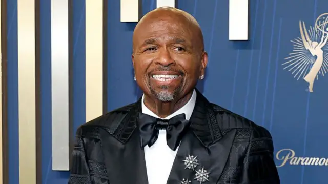 William Stanford Davis from Abbott Elementary walks the red carpet in a black suit