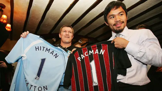 Hatton and Pacquiao smiling holding footbal shirts with their name and the number 1 on the back