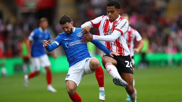 Portsmouth's Conor Chaplin holds off the challenge of Saints' Shea Charles