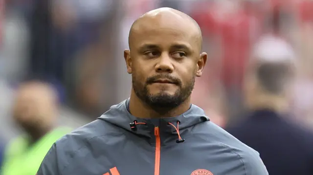 A man in a grey and orange jacket