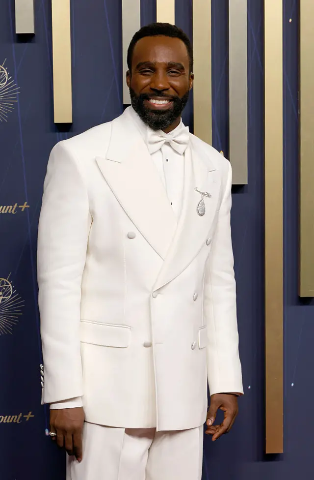 Tramell Tillman walks the carpet in a white suit