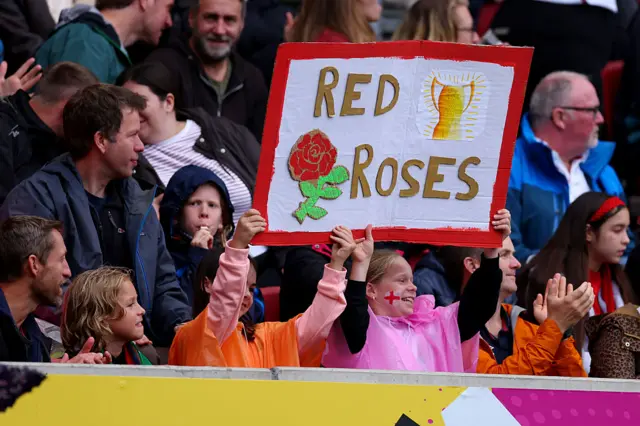 Fans holding red roses sign