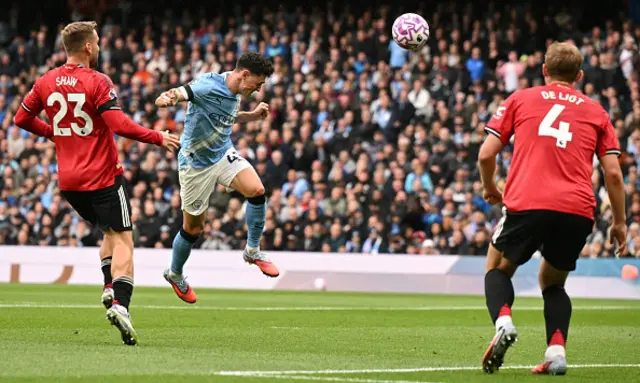 Phil Foden (C) heads the ball to score the opening goal