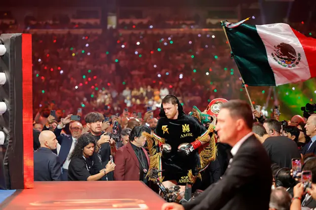 Saul Canelo Alvarez enters the ring flanked by a massive Mexico flag