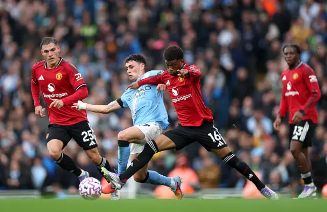 Phil Foden of Manchester City is challenged by Manuel Ugarte and Amad Diallo