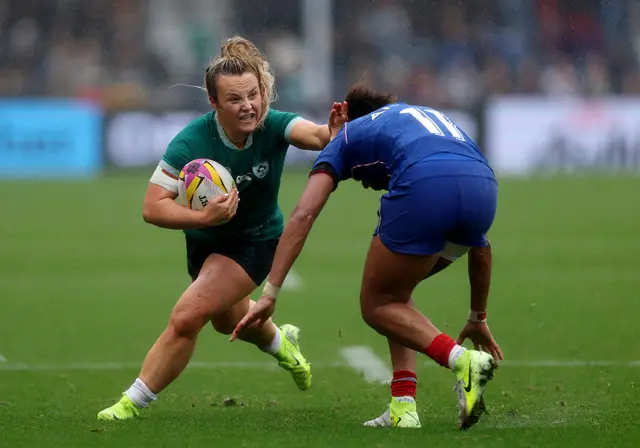 Aoife Dalton of Ireland runs with the ball whilst under pressure from Kelly Arbey of France