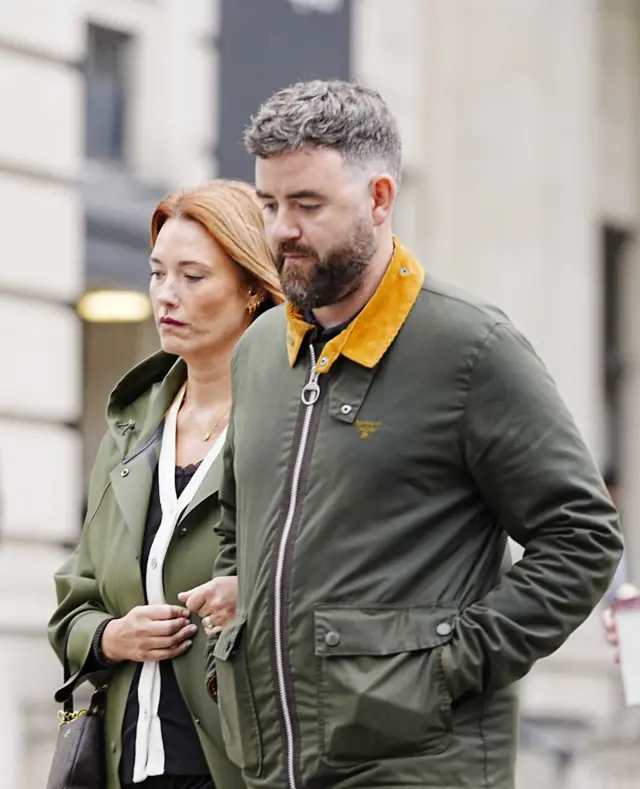Lauren King, who has long red hair, walks arm in arm with Ben King, who has a brown beard and brown and grey hair.