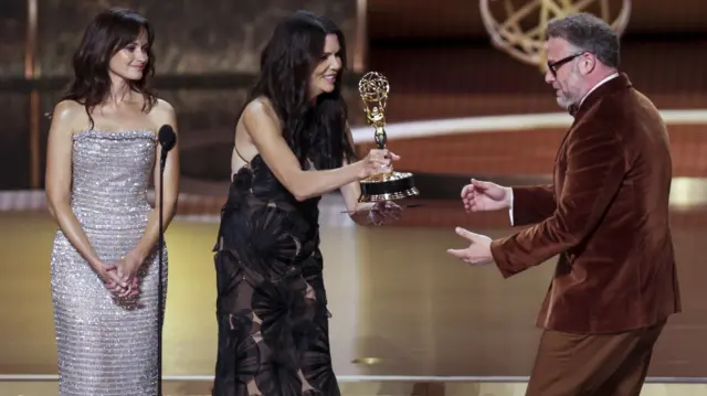 Alexis Bledel and Lauren Graham present Seth Rogen and Evan Goldberg the Emmy for Outstanding Writing for a Comedy Series for 'The Studio' during the 77th annual Emmy Awards ceremony