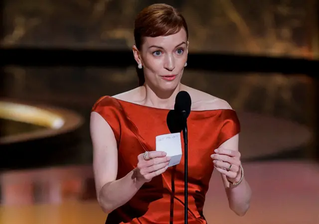 Britt Lower holds an acceptance speech note that has "let me out" written on it