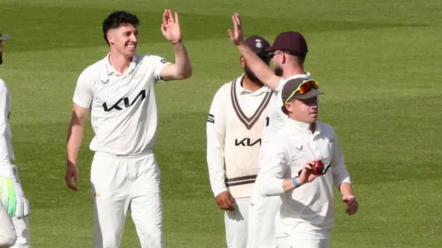 Surrey players congratulate Matt Fisher on another wicket