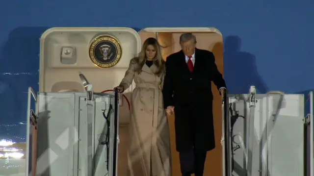 Melania (left) and Trump in the doorway of Air Force One