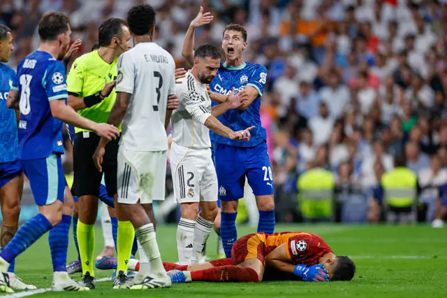 Real Madrid's Spanish defender #02 Dani Carvajal (2R) gestures at Marseille's Argentine goalkeeper #01 Geronimo Rulli after a scuffle during the UEFA Champions League first round day 1 football match between Real Madrid CF and Olympique de Marseille at the Santiago Bernabeu stadium in Madrid on September 16, 2025.