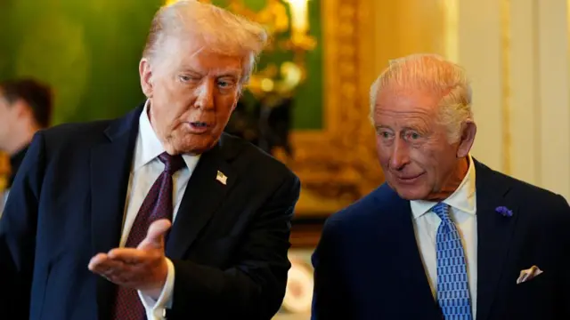 Donald Trump gestures as the King looks on