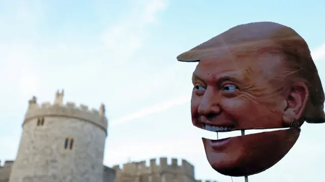 A cardboard cutout of Donald Trump's head is held up during a protest in London