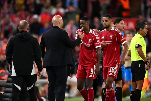 Cody Gakpo and Alexander Isak of Liverpool with Arne Slot, Manager of Liverpool, as they are substituted
