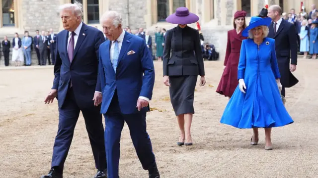 The King walks with President Trump ahead of Queen Camilla and Melania. Kate and William can be seen just behind