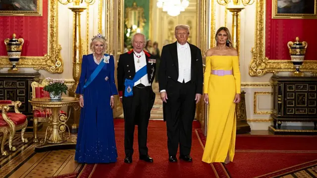 The Queen, the King, Donald Trump and Melania pose next to one another in formal attire inside St George's Hall.
