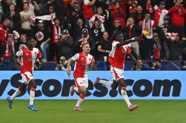 Slavia Prague's Senegalese defender #12 Youssoupha Mbodji (R) celebrates scoring his team's first goal with team mates during the UEFA Champions League football match between SK Slavia Prague and FK Bodoe/Glimt in Prague on September 17, 2025.