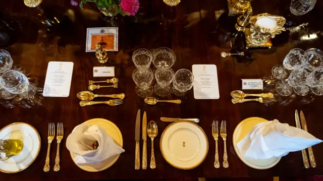 An overhead shot of President Trump and the King's places on the table. A number of glasses are laid at each place along with various cutlery
