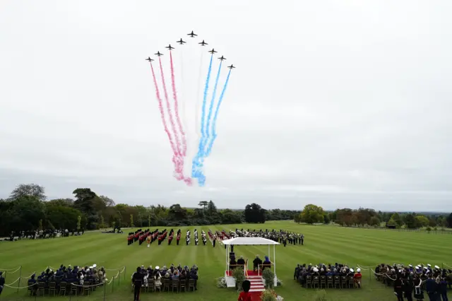 Red Arrows fly over Windsor's East Lawn, where Melania Trump, Donald Trump, the King and Queen are sitting under a white canopy observing