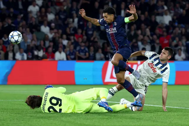 Paris Saint-Germain's Brazilian defender #05 Marquinhos (C) shoots past Atalanta's Italian goalkeeper #29 Marco Carnesecchi (L) to score PSG's first goal