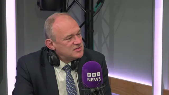 Ed Davey speaks into a mic