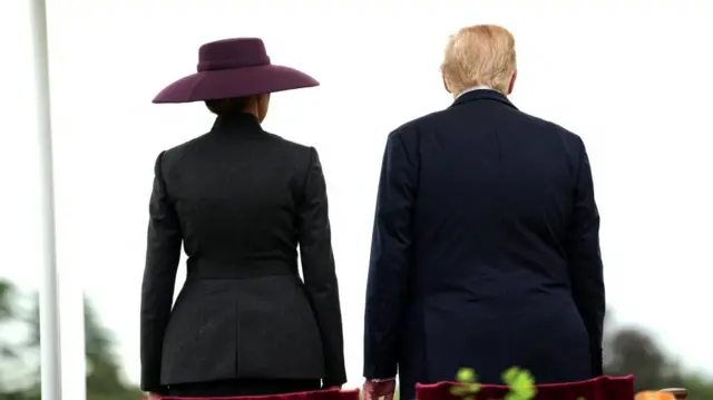 Melania and Trump are seen from behind