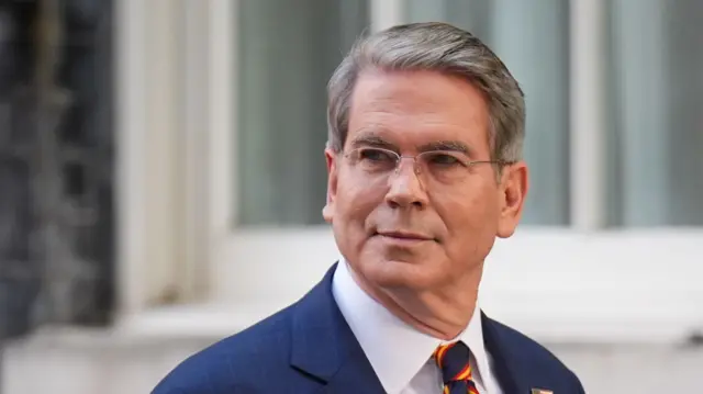 A headshot of Scott Bessent, the background is blurred