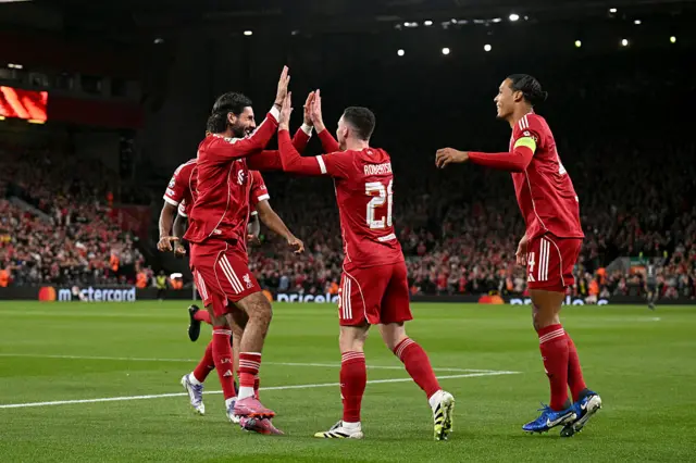 Liverpool's Scottish defender #26 Andrew Robertson (C) celebrates with teammates scoring his team's first goal during the UEFA Champions League first round football match between Liverpool and Atletico Madrid at Anfield in Liverpool, north west England on September 17, 2025.