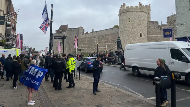 Groups of people stand outside Windsor Castle