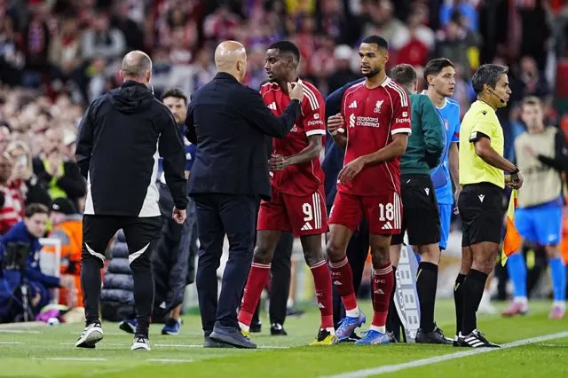 Liverpool's Alexander Isak (centre) is embraced by manager Arne Slot after being substituted