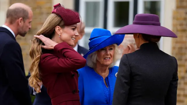 Queen Camilla in a blue, and Catherine in red.