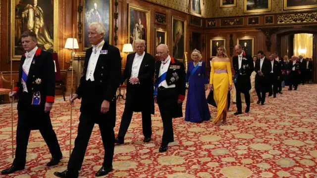 A royal procession walks into St George's Hall for a state banquet