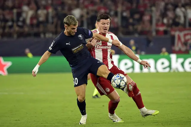 Pafos FC's Romanian midfielder #30 Vlad Dragomir (L) and Olympiakos' French defender #04 Giulian Biancone fight for the ball during the UEFA Champions League football league stage match between Olympiakos and Pafos at the Karaiskakis stadium in Piraeus on September 17, 2025.