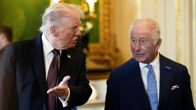Donald Trump stood next to King Charles, both wearing suits and in conversation.