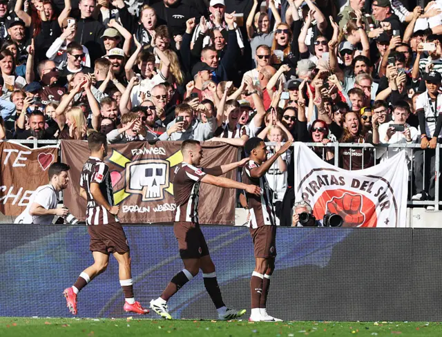 St. Pauli in black and white celebrate Andreas Hountondji against Augsburg last game week.