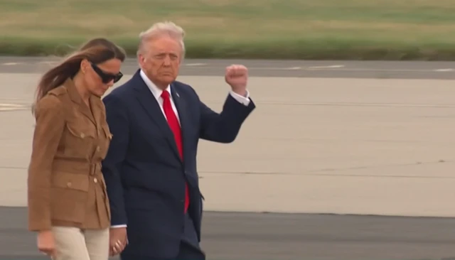 Trump and Melania on airport runway.