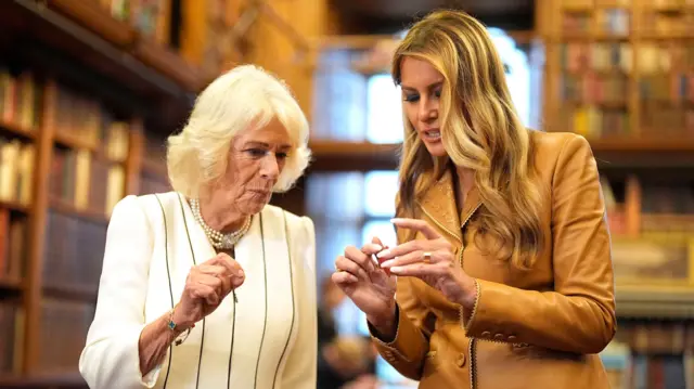 Queen Camilla (L) and Melania Trump (R) view miniature books inside Royal library at Windsor Castle