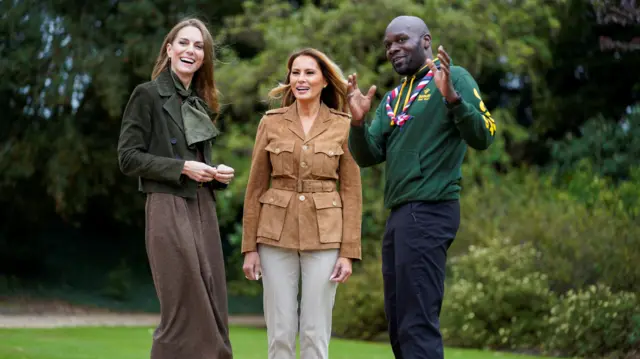 Britain's Catherine, Princess of Wales and U.S. first lady Melania Trump are welcomed by Chief Scout for the Scout Association Dwayne Fields as they tour Frogmore Gardens