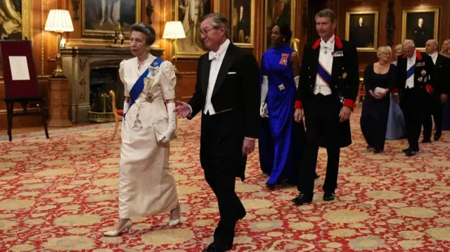 The Princess Royal walks with US Ambassador to the UK, Warren Stephen, followed by Vice Admiral Sir Tim Laurence and Dame Vivian Hunt, at the state banquet at Windsor Castle
