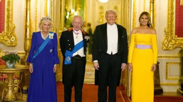 Queen Camilla, wearing a blue dress and tiara, The king and Trump in banquet attire, and Melania Trump is wearing a bright yellow, long sleeved dress