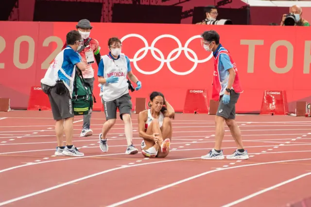 Katarina Johnson-Thompson of Great Britain is attended to by medical staff after injury