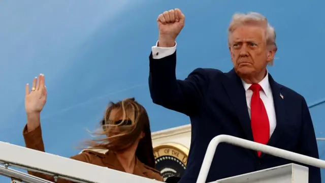 U.S. President Donald Trump and first lady Melania Trump gesture as they board Air Force One.
