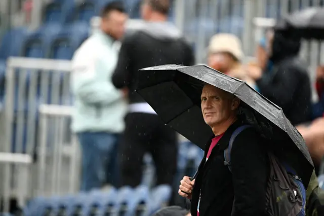 Spectator under umbrella