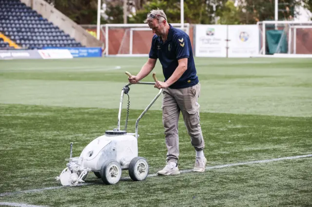 Groundsman paints lines on pitch at Rugby Park