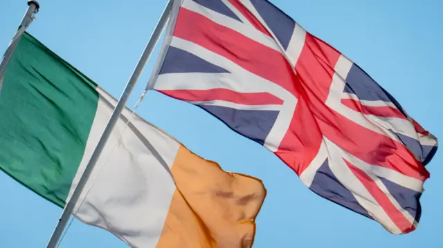 The flags of the Republic of Ireland and the United Kingdom of Great Britain and Northern Ireland on flagpoles on a building